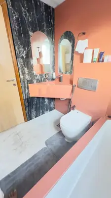 a bathroom with a toilet and two mirrors at Metro Access,Insulated in Dubai