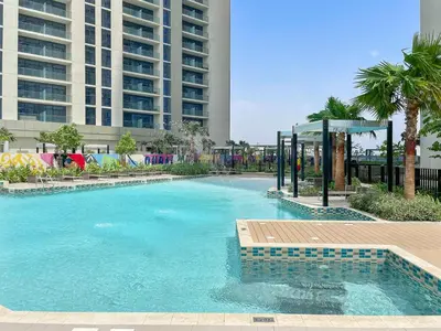 a swimming pool with a gazebo next to a building at Silkhaus Spacious 2BR in Aykon City Near Safa Park in Dubai
