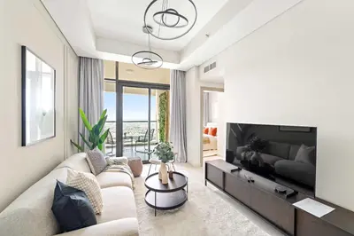 a living room with a couch and a television at Silkhaus Spacious 2BR in Aykon City Near Safa Park in Dubai