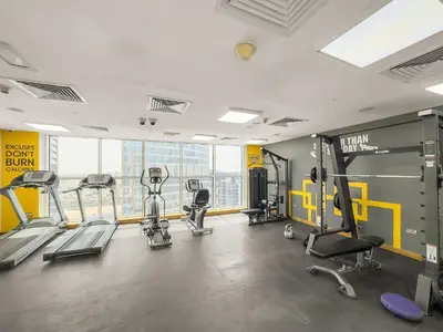 a gym with treadmills and machines in a building at Silkhaus Homey 2BR at Mayfair Tower in Business Bay in Dubai