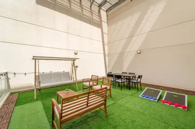 a room with benches and a table and grass at Silkhaus Homey 2BR at Mayfair Tower in Business Bay in Dubai