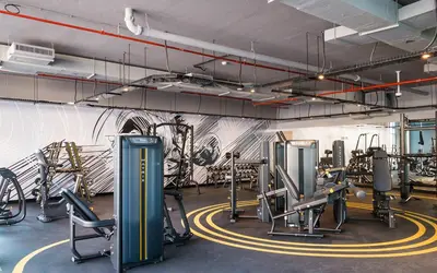 a gym with cardio equipment and a wall with graffiti at The Designers Apartment Dubai Marina in Dubai