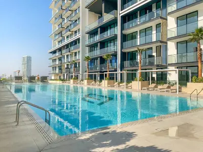 a large swimming pool in front of a building at VayK - Luxury 2BR with Jacuzzi in JVC in Dubai