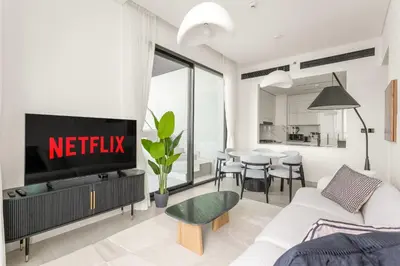 a living room with a netflix sign on a wall at VayK - Luxury 2BR with Jacuzzi in JVC in Dubai