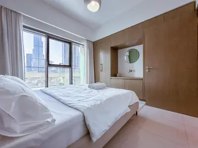 a bedroom with a large bed with a large window at Spectacular Burj Khalifa View, 2BR Luxury Apartment by SBH in Dubai