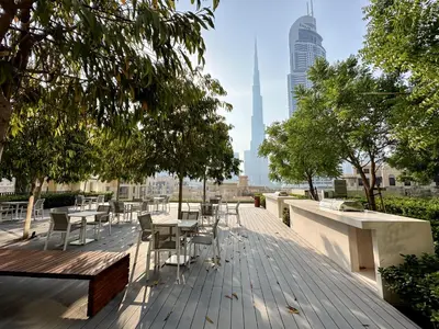 a deck with tables and chairs and a view of a city at Spectacular Burj Khalifa View, 2BR Luxury Apartment by SBH in Dubai