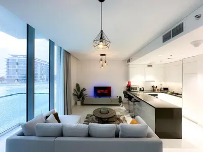 a living room with a couch and a table at Luxury 1BR with Aquatic View, District One in Dubai