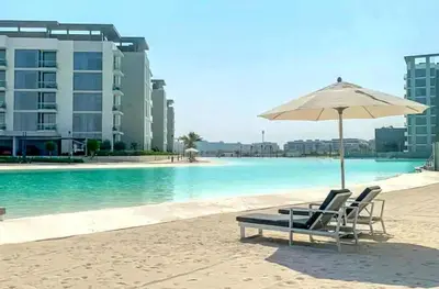 a pair of chairs and an umbrella on the beach at Luxury 1BR with Aquatic View, District One in Dubai