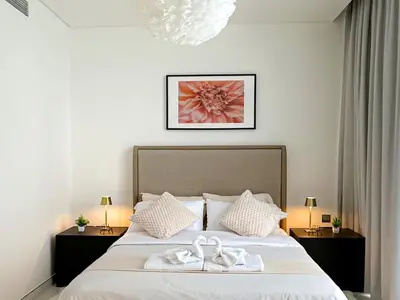 a bedroom with a bed with two white towels on it at Luxury 1BR with Aquatic View, District One in Dubai