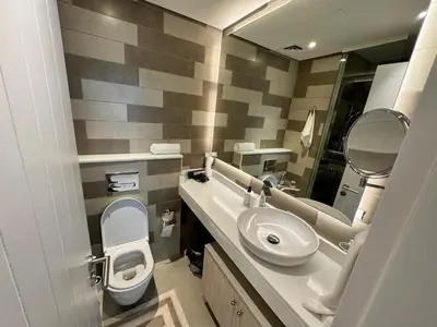 a bathroom with a sink and a toilet and a mirror at Dubai Palm Jumeirah - Free Infiniti Pool and Private Beach in Dubai