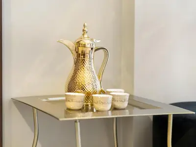 a tea kettle and three cups on a table at Burj Khalifa View Luxury Apt - 7 min to Dubai Mall in Dubai