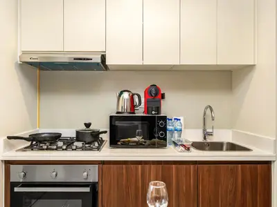 a kitchen with a microwave and a stove and a sink at Burj Khalifa View Luxury Apt - 7 min to Dubai Mall in Dubai