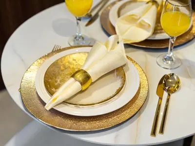 a table with a plate with a napkin and a fork and knife at Burj Khalifa View Luxury Apt - 7 min to Dubai Mall in Dubai