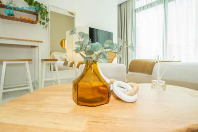 a yellow vase with flowers in it on a table at Blue Breeze - Elegant Studio in Serenity Lake 5, JVC in Dubai