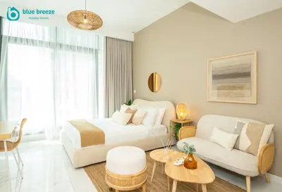 a hotel room with a bed and a couch at Blue Breeze - Elegant Studio in Serenity Lake 5, JVC in Dubai