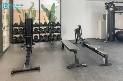 a gym with several treadmills and weights at Blue Breeze - Elegant Studio in Serenity Lake 5, JVC in Dubai