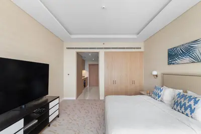 a hotel room with a bed and a flat screen tv at Sea View Apartment by St Regis 5 stars Infinity Pool in Dubai
