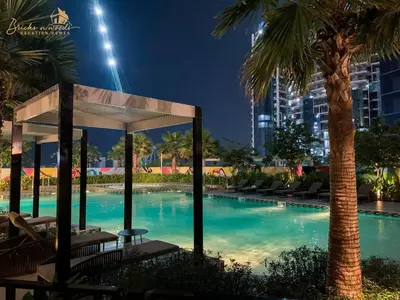 a swimming pool at night with a gazebo and palm trees at Magnificent Canal View 2 Bhk 6 pax in Dubai