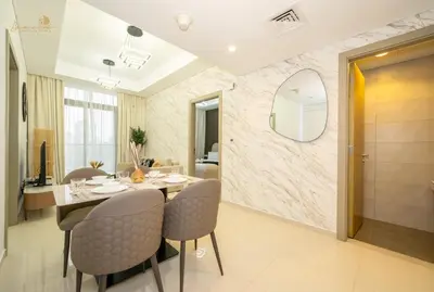 a dining room with a table and chairs and a mirror at Magnificent Canal View 2 Bhk 6 pax in Dubai