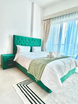 a bedroom with a bed with a blue headboard and a window at Stunning 2BR Marina View Apt Close to JBR in Dubai