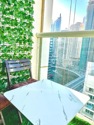 a table and chair in front of a window at Stunning 2BR Marina View Apt Close to JBR in Dubai