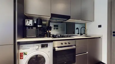 a kitchen with a washer and a washing machine at O Ten Al Jaddaf - Stylish Studio in Dubai