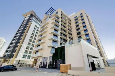 two tall buildings with a car parked in front of them at O Ten Al Jaddaf - Stylish Studio in Dubai