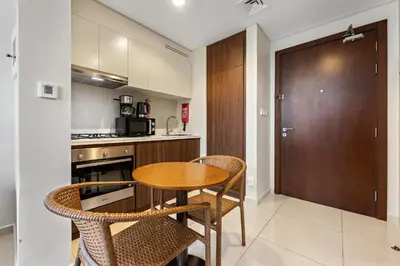 a kitchen with a wooden table and chairs in a kitchen at Apartment in Downtown Dubai in Dubai