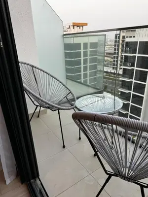 a balcony with two chairs and a table on a building at Sunlit serenity Studio Azizi Riviera in Dubai