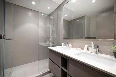 a bathroom with a sink and a glass shower at Gogoto1 Ultra LUX Burj View Spacious High Floor PS5 NYE Fireworks View in Dubai