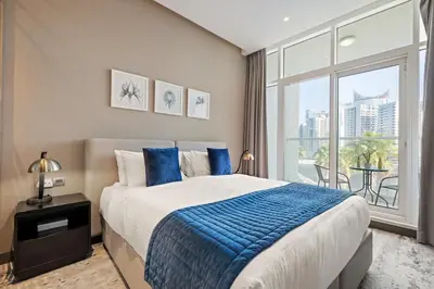 a bedroom with a large bed and a large window at Damac Maison Prive, Lake View - Free Parking in Dubai