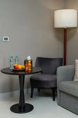 a room with a table with fruit and a chair at Damac Maison Prive, Lake View - Free Parking in Dubai