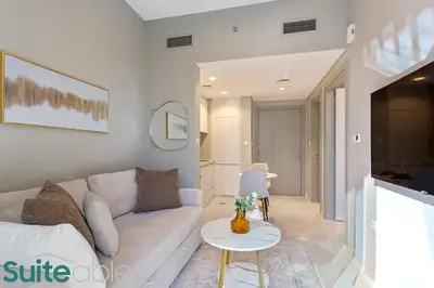 a living room with a white couch and a table at Modern and Relaxing 1 Bedroom in Zada Tower in Dubai