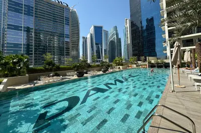 a large swimming pool in a city with tall buildings at Modern and Relaxing 1 Bedroom in Zada Tower in Dubai