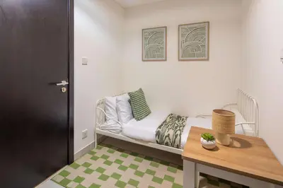 a small room with a bed and a table at Frank Porter - Green Lakes in Dubai