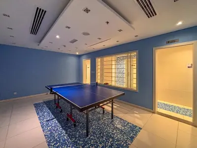 a ping pong table in a room with blue walls at Frank Porter - Green Lakes in Dubai