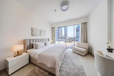 a white bedroom with a bed and a window at Brand new 1BD apartment in Canal Front Residence in Dubai