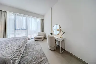 a bedroom with a bed and a mirror and a chair at Brand new 1BD apartment in Canal Front Residence in Dubai