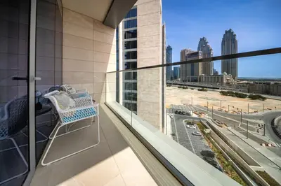 a balcony with a chair and a view of a city at Brand new 1BD apartment in Canal Front Residence in Dubai