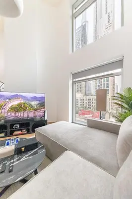 a living room with a tv and a couch at 3BR Loft I Burj Khalifa & Mall in Dubai