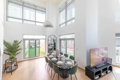 a dining room with a table and a tv at 3BR Loft I Burj Khalifa & Mall in Dubai