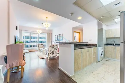 a kitchen and living room with a table and chairs at Affordable Living 1BR, Steps from Retail Stores, Skycourts Tower D, Dubailand by Deluxe Holiday Homes in Dubai