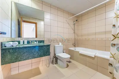 a bathroom with a toilet and a tub and a sink at Affordable Living 1BR, Steps from Retail Stores, Skycourts Tower D, Dubailand by Deluxe Holiday Homes in Dubai