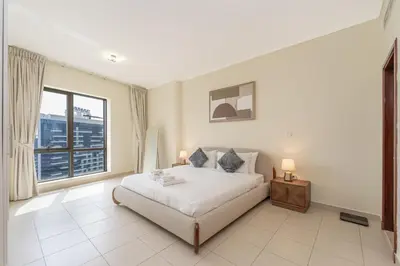 a bedroom with a bed and a large window at Downtown Retreat 1BR with Skyline Views & WiFi in Dubai