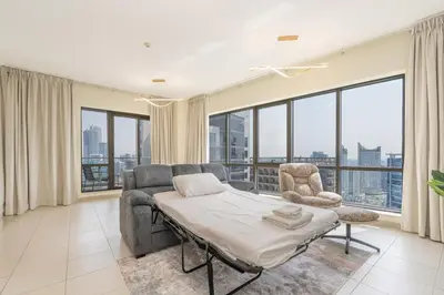 a room with a bed and a couch and chairs at Downtown Retreat 1BR with Skyline Views & WiFi in Dubai