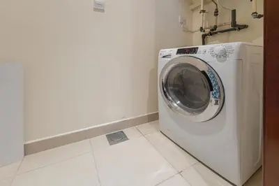 a washing machine in a laundry room with a tile floor at Downtown Retreat 1BR with Skyline Views & WiFi in Dubai