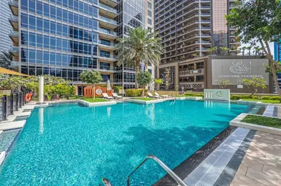 a large blue swimming pool with tall buildings at Downtown Retreat 1BR with Skyline Views & WiFi in Dubai