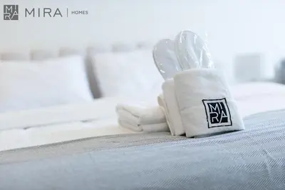 a pile of towels sitting on top of a bed at Mira Holiday Homes - Bright studio with Burj Khalifa view in Business Bay in Dubai