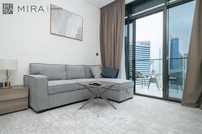a living room with a couch and a table at Mira Holiday Homes - Bright studio with Burj Khalifa view in Business Bay in Dubai