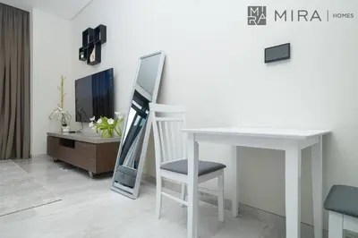 a mirror sitting on a table next to a white desk at Mira Holiday Homes - Bright studio with Burj Khalifa view in Business Bay in Dubai